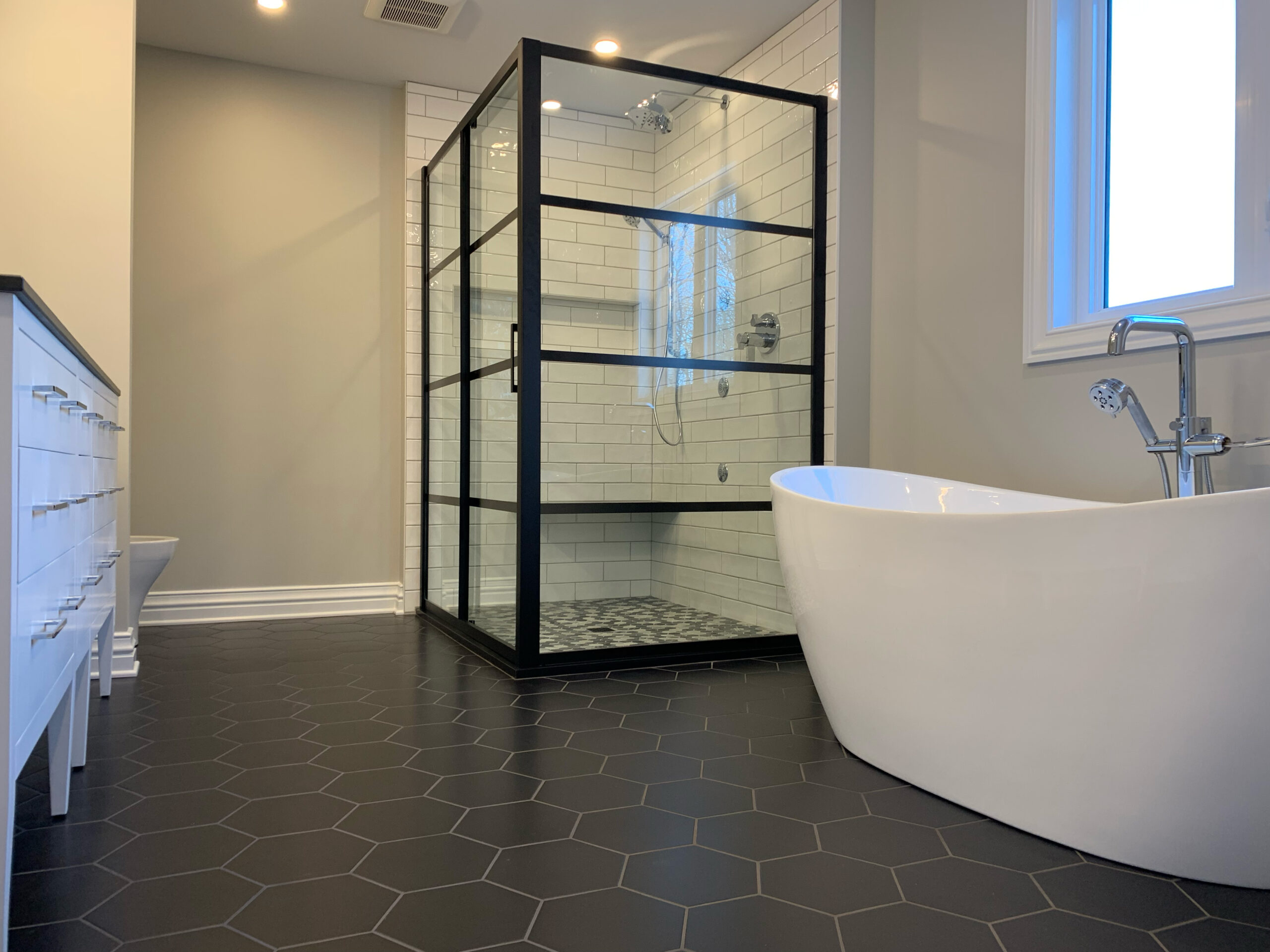 Freestanding tub with black framed glass shower