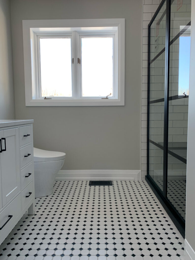 Bright bathroom with freestanding tub and patterned floor