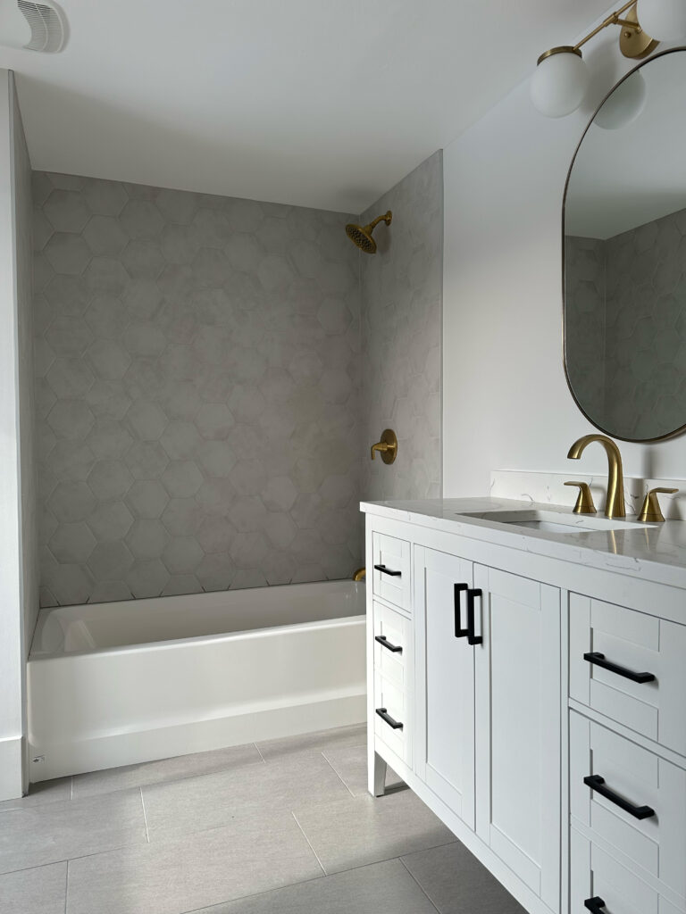 Bathroom renovation with white vanity and tub