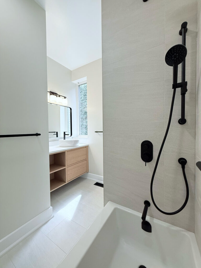 Bright bathroom with white tub and black fixtures